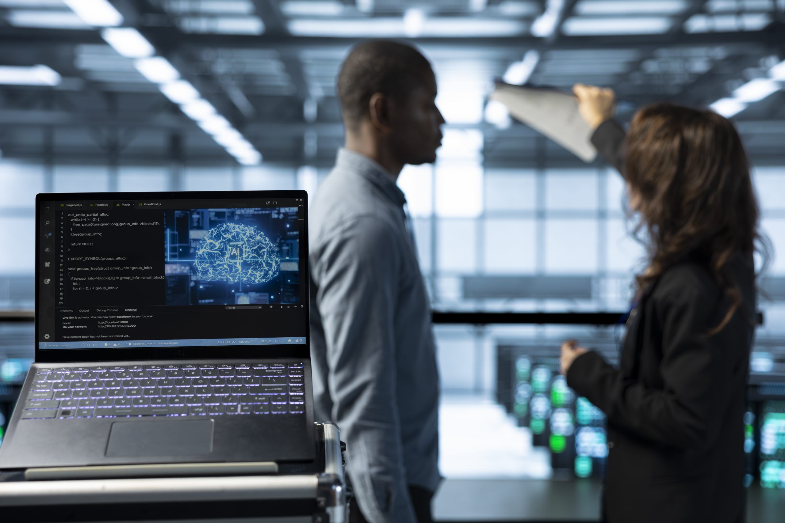 Close up of AI coding on notebook screen next to technicians